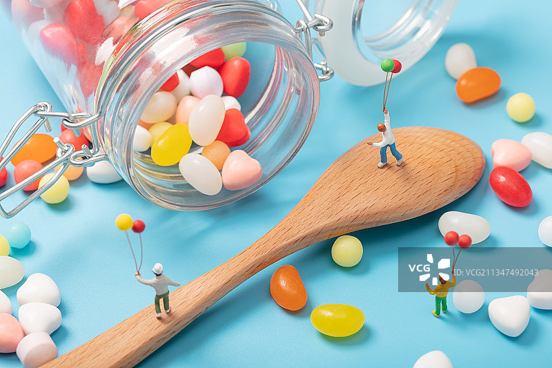 微缩创意打翻的糖果罐里木勺上拿着气球的儿童图片素材
