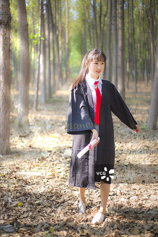 树林里穿着学士服的女孩图片素材