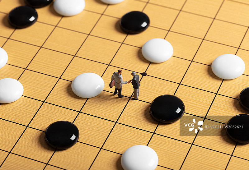 微缩创意围棋棋盘策略格局谈判合作握手和棋图片素材