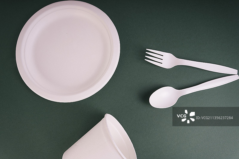 一次性餐具，由纸和塑料制成，底色为深绿色。图片素材