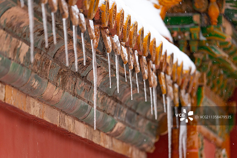 雪中故宫屋檐琉璃瓦下的冰挂特写图片素材