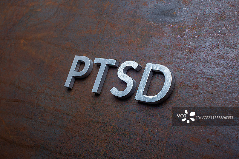 单词P T S D与银色的金属字母铺设在扁平生锈的钢图片素材