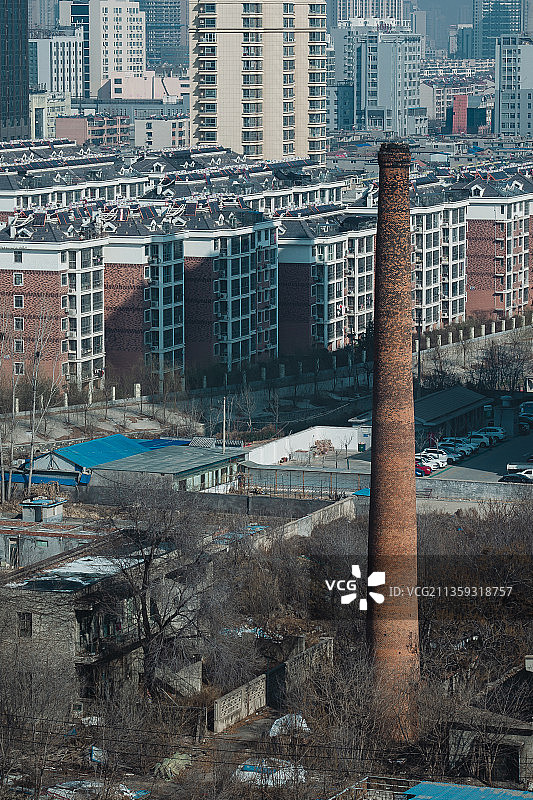 中国山东泰安航拍城市住宅区里的破旧厂房和高大的烟囱图片素材