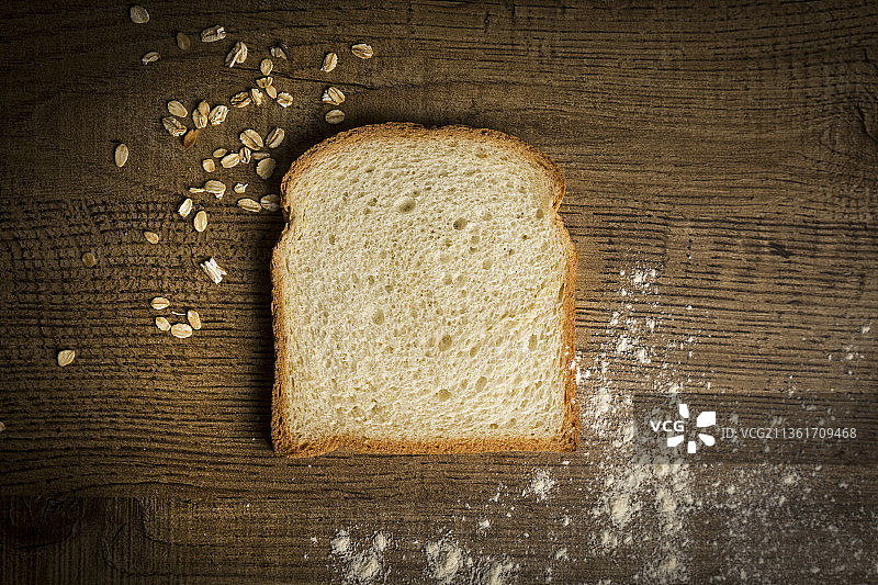 一片面包，正对着桌上的一小片面包图片素材