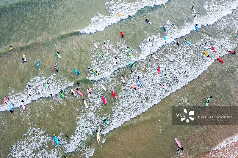 海南省三亚市海棠区后海度假村游客正在海边冲浪图片素材