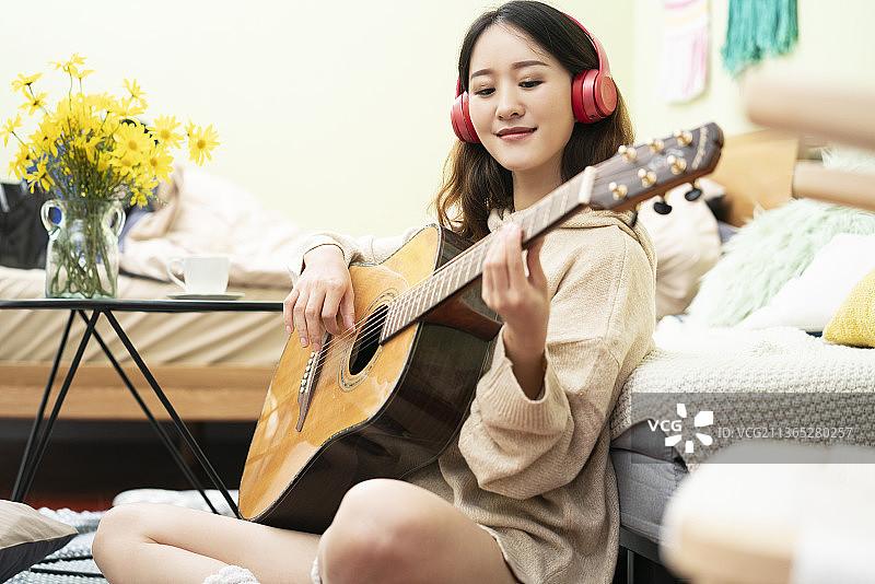 年轻女士在家弹吉他图片素材