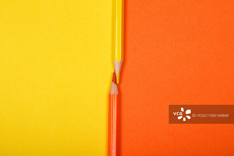 两支彩色铅笔分别在两张不同颜色的纸上图片素材