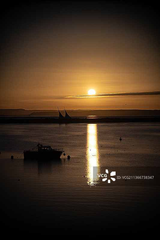 卡迪夫湾日出，日落时在天空中小船的轮廓，卡迪夫湾，英国，英国图片素材