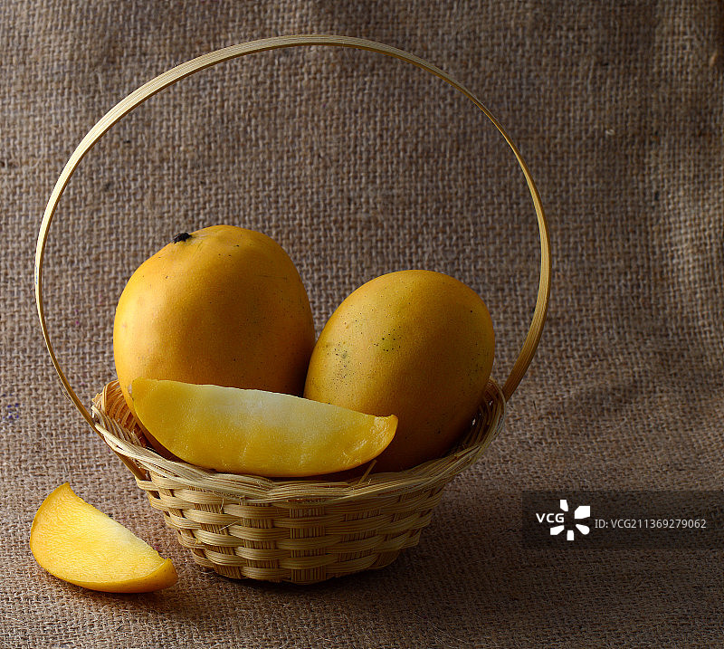 芒果水果篮在麻袋布背景图片素材
