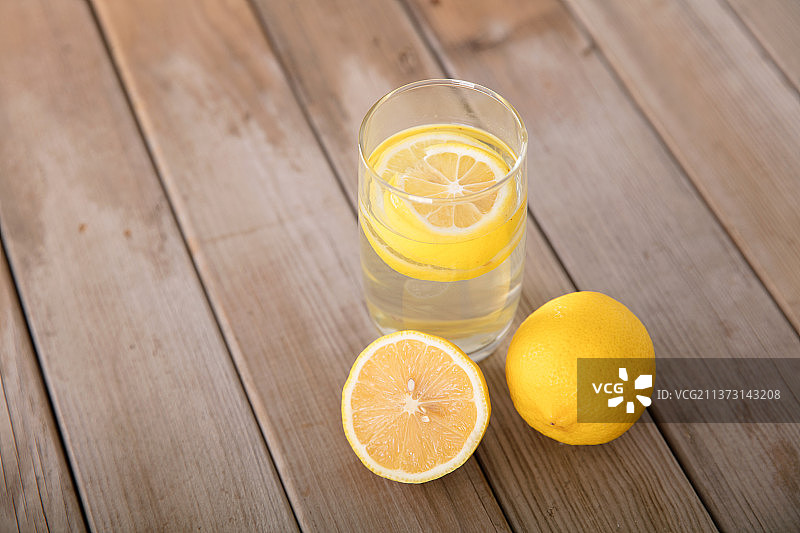 桌子上的黄柠檬和一杯柠檬水图片素材