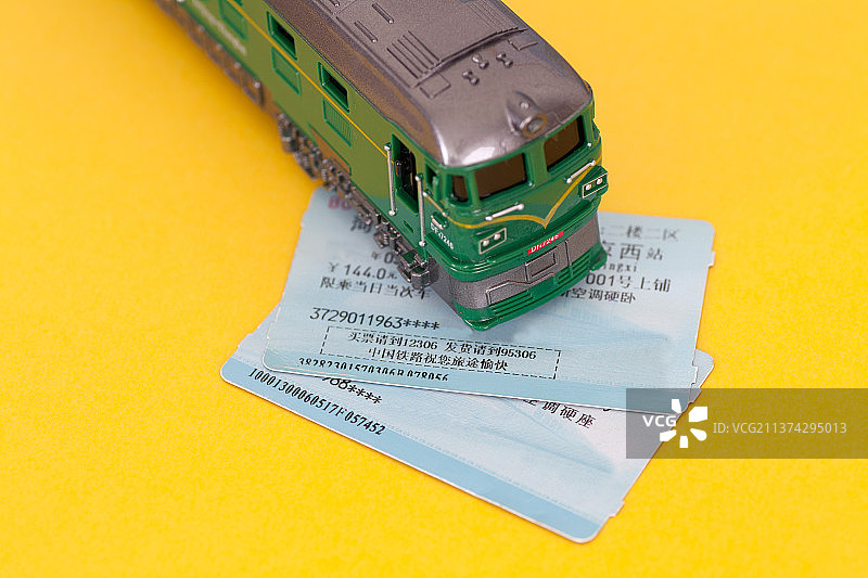 一辆绿皮火车模型和两张火车票图片素材
