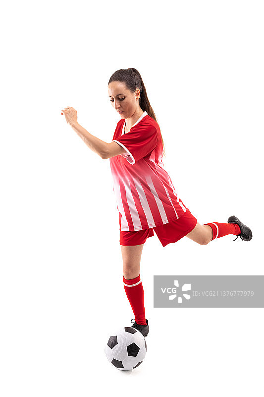 白人年轻女球员在踢足球时，足球的背景是白人图片素材