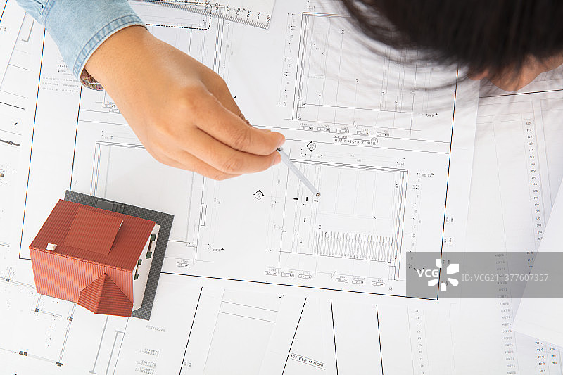 建筑设计工程师通过各种测量房屋模型来检查施工图图片素材