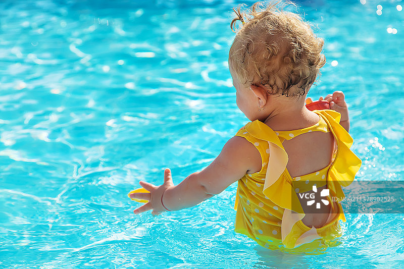 宝宝在泳池里游泳选择性聚焦图片素材