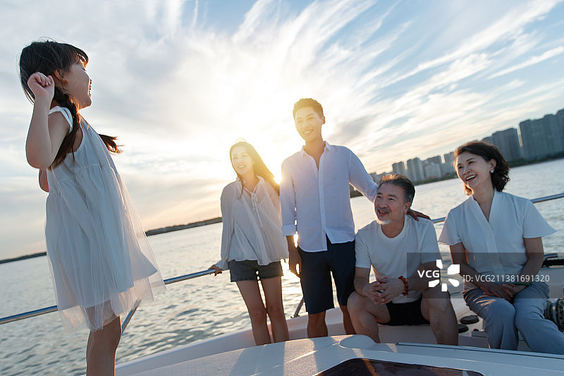 夕阳下在游艇上的快乐一家人图片素材
