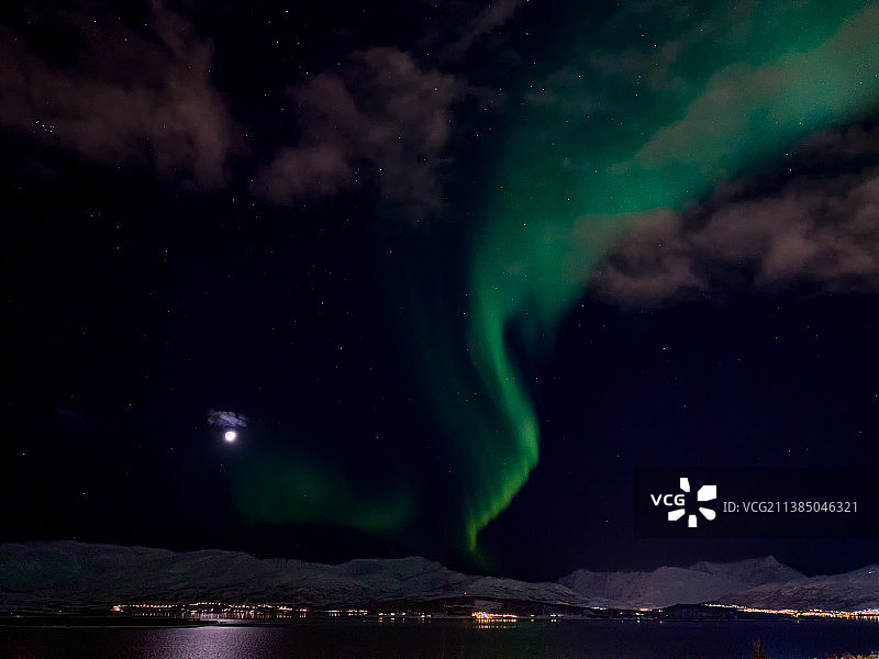 北极光，在挪威南森芬根，夜晚被照亮的山脉映衬着天空的风景图片素材