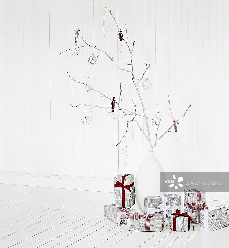 树枝上插着的圣诞装饰物和用报纸包裹的礼物图片素材