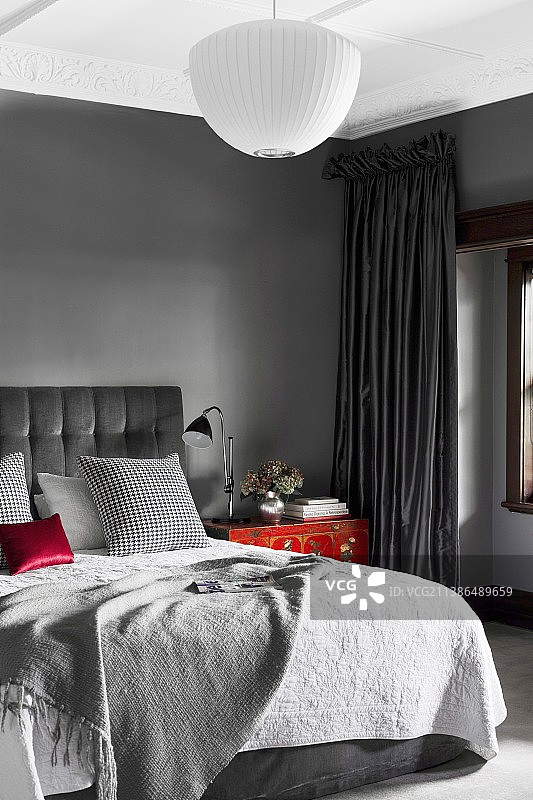 优雅的卧室在灰色色调与红色口音图片素材