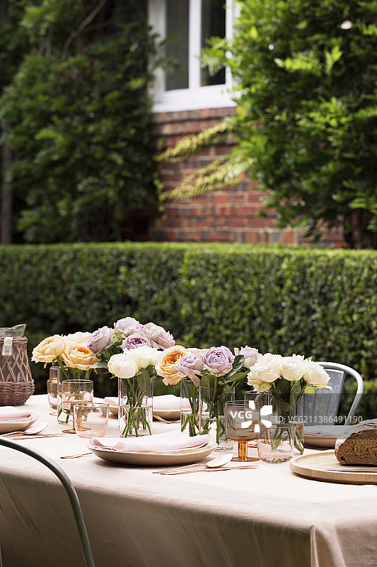 几束鲜花放在简单摆放的花园餐桌上图片素材
