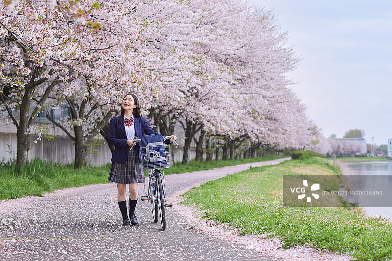 推自行车的日本女高中生图片素材