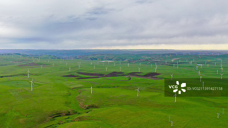 航拍视角下的草原上的风力发电场图片素材