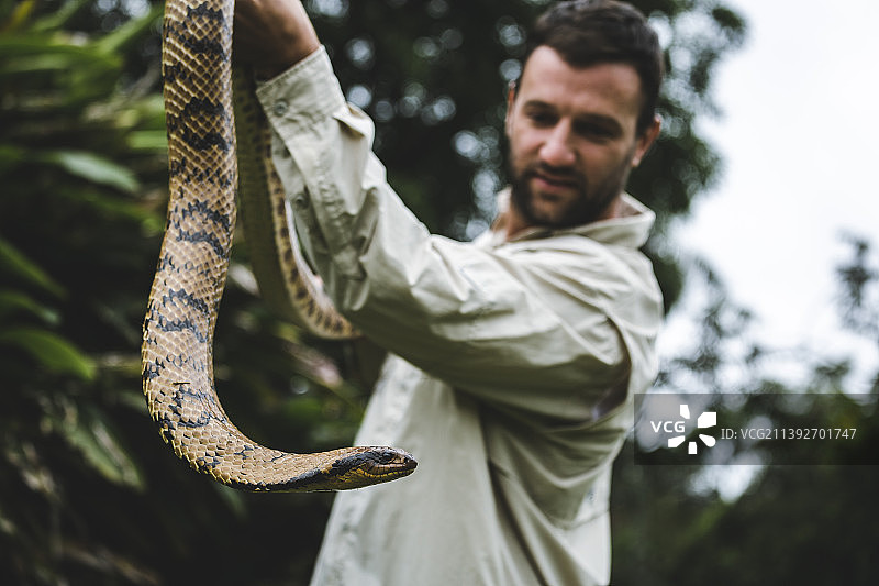 男人拿着毒蛇,科连特斯,阿根廷图片素材