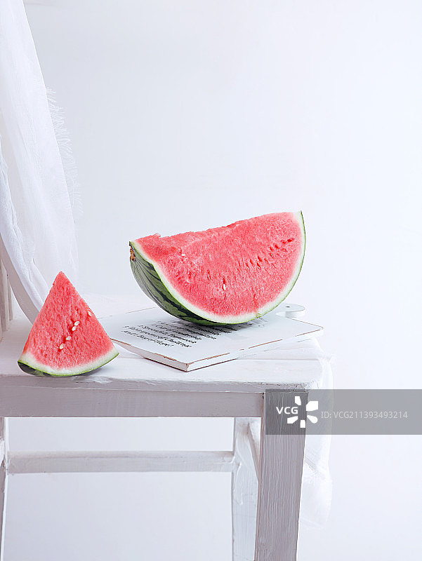 白色桌面上摆放着的新鲜夏日水果西瓜图片素材