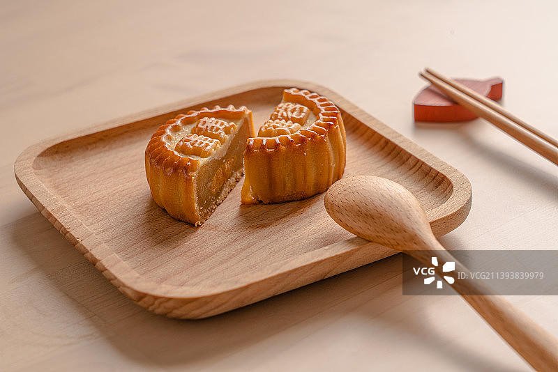 竹木餐盘里的切剖开的广式月饼静物图片素材