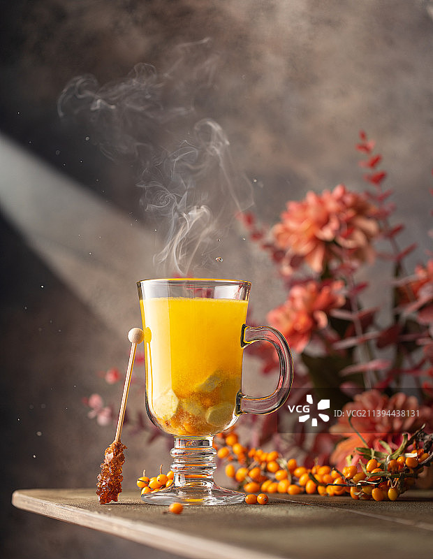 热沙棘茶，盛于盛有新鲜成熟浆果的玻璃杯中图片素材
