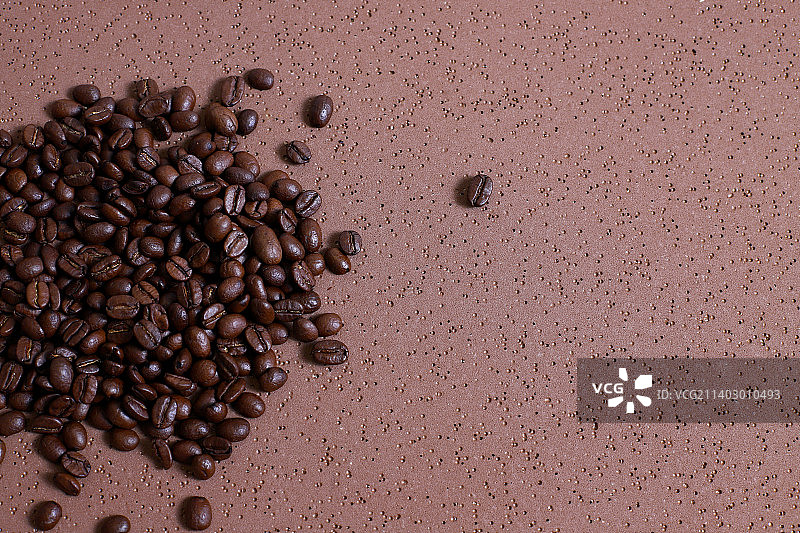 咖啡豆在棕色的桌子上烤图片素材