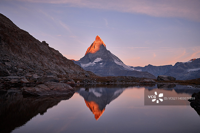 在瑞士策尔马特马特洪峰冰川，日落时湖泊和山脉映衬着天空的风景图片素材
