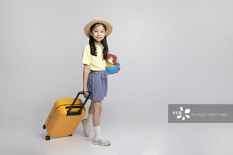 一个穿着运动服的韩国小女孩在白色背景的工作室里去度暑假图片素材