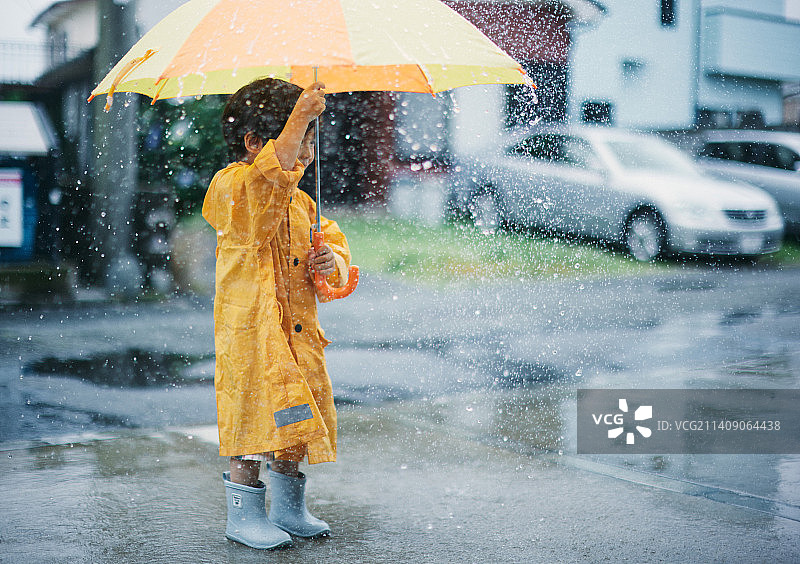 一个日本小孩下雨天在外面玩图片素材
