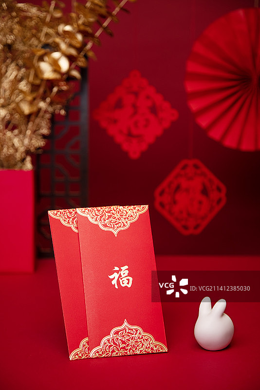 桌子上的红包与兔子,红色背景,新年气氛图片素材
