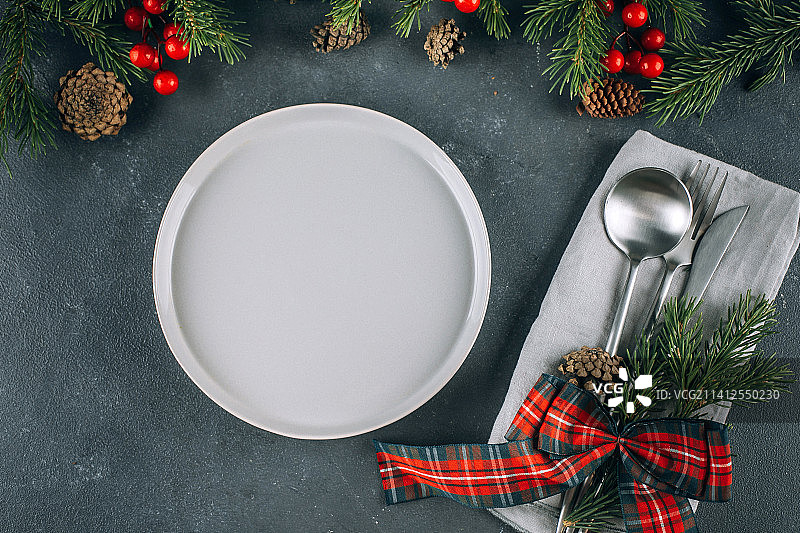 节日的餐桌上设置蓝色的桌子白色的盘子和银器圣诞节日装饰，哈萨克斯坦图片素材