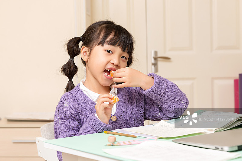 室内吃桔子的小女孩图片素材