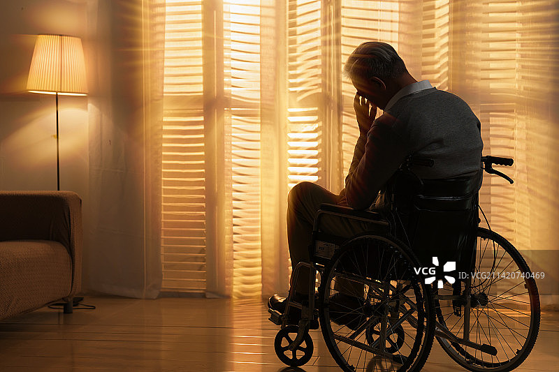 窗前孤独的老年人坐在轮椅上图片素材