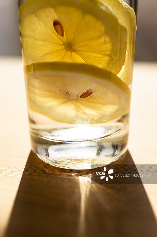 阳光照射下的玻璃杯中的柠檬切片图片素材
