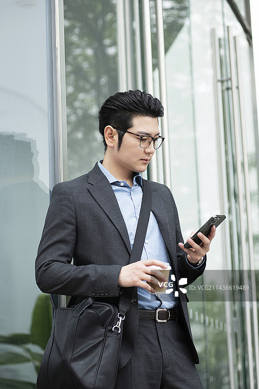 年轻商务男士在户外使用手机 喝咖啡图片素材
