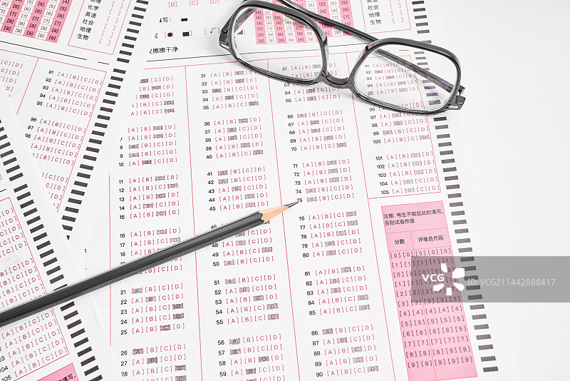 考试答题卡上放着一支笔和眼镜图片素材