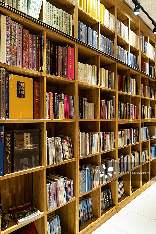 中国图书馆拍摄主题，弯曲的书柜书架子上陈列着各种各样的书籍，室内无人图像图片素材