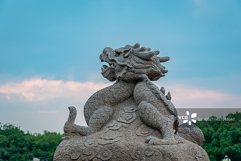 蓝天下的日落时分晚霞满天，无锡宜兴太湖边团氿公园里的生肖中国龙雕像栩栩如生图片素材