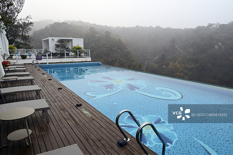 山里豪华酒店（民宿）游泳池旁的空椅子和桌子图片素材