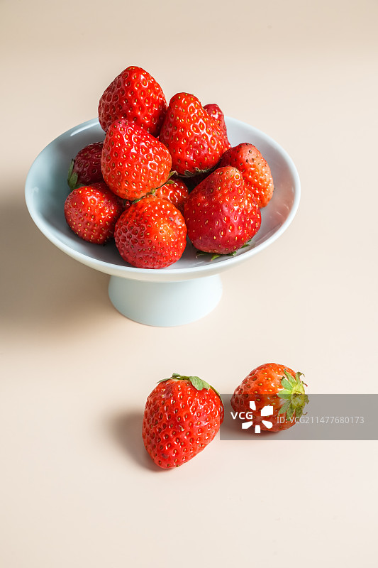 一盘新鲜的草莓放在桌面上图片素材