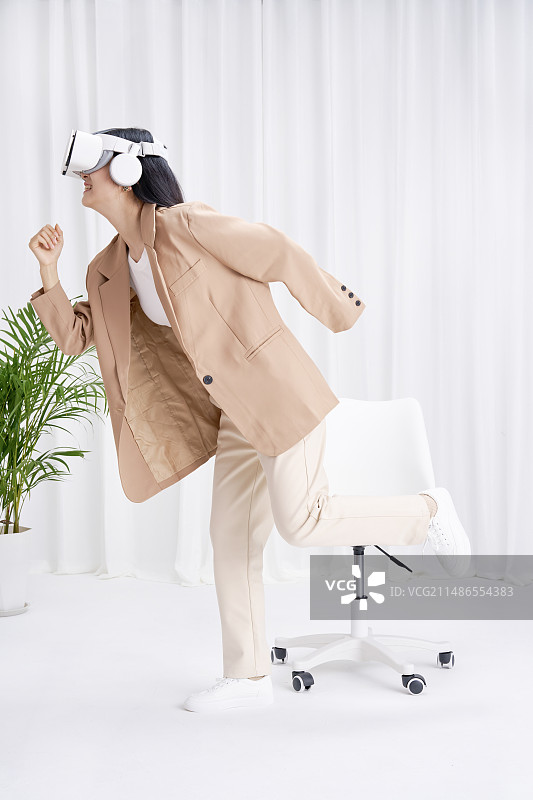 头戴VR在办公室内的年轻女孩图片素材
