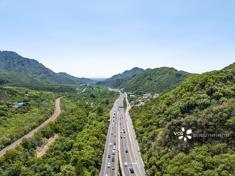 航拍夏天绿色崇山峻岭中的八达岭高速公路和车流风景图片素材