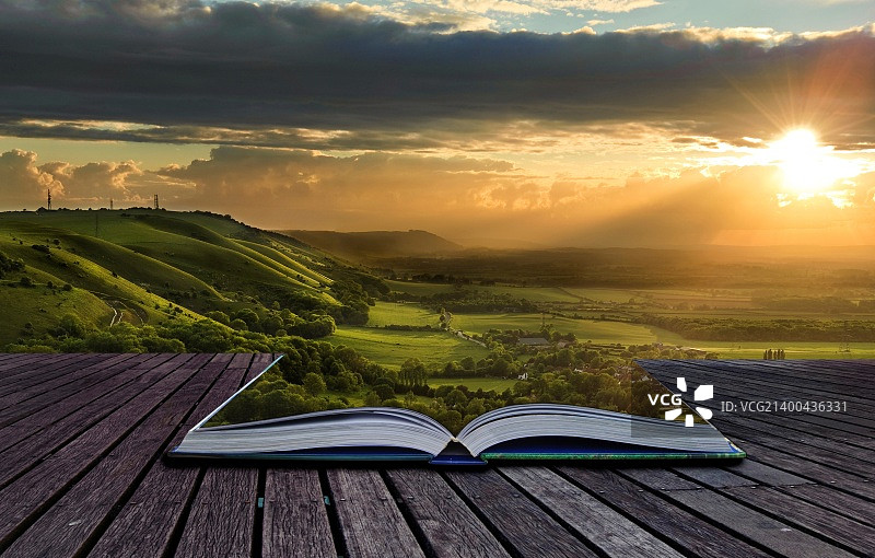 美丽的日落横跨乡村溢出魔法书，创造惊人的风景背景图片素材