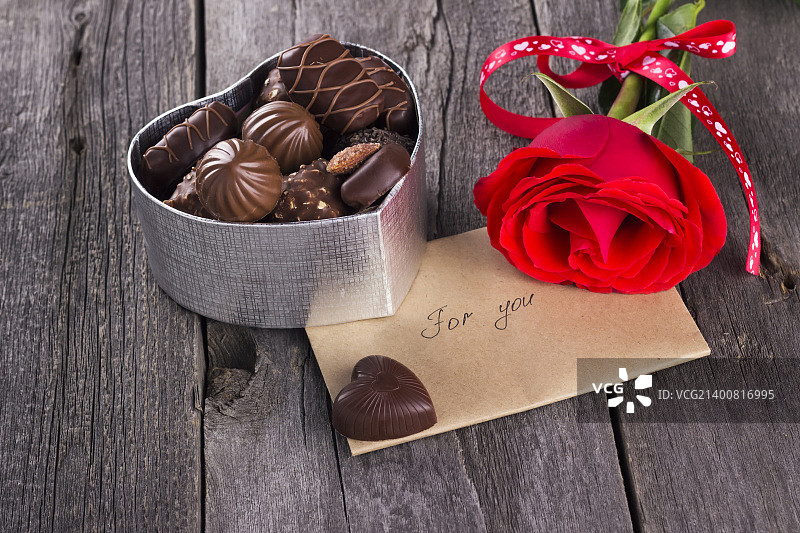 一盒巧克力，黑背景上的红玫瑰图片素材