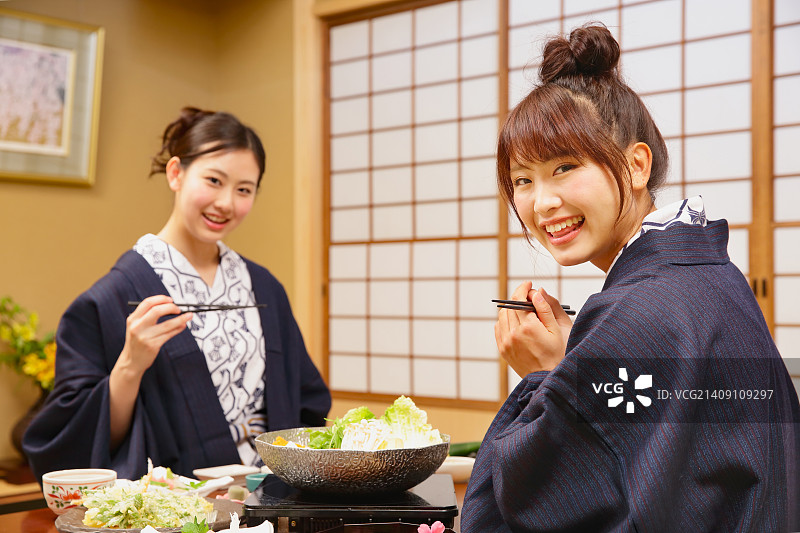 年轻的日本妇女穿着浴衣在传统的日式客栈吃饭图片素材
