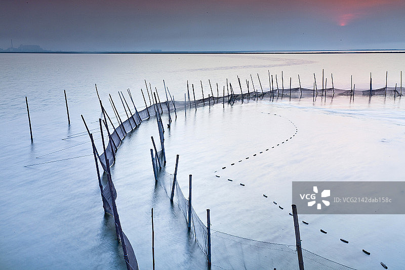 水面渔网围栏和落日图片素材